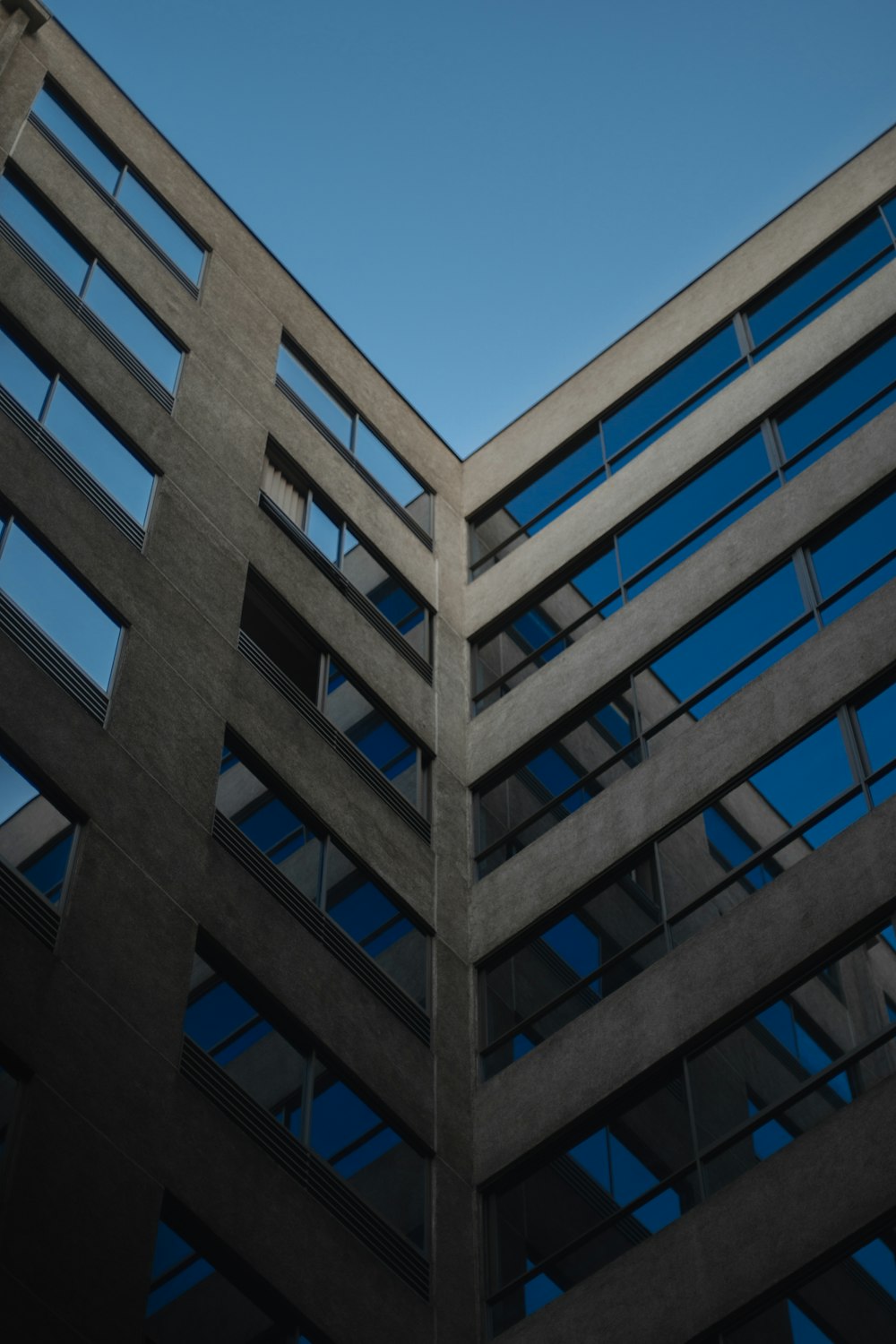 Bâtiment en béton blanc sous le ciel bleu pendant la journée