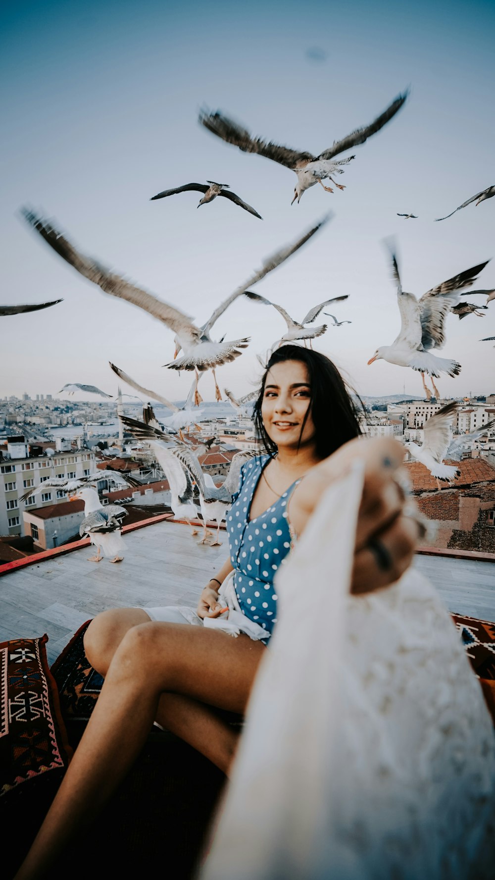 mulher no vestido azul e branco das bolinhas sentado na cadeira vermelha