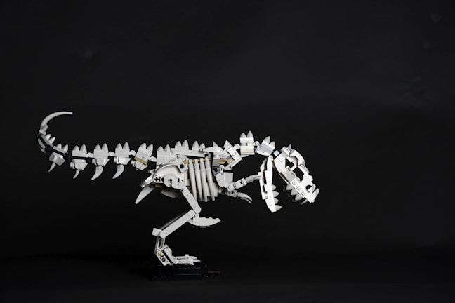 Close-up of a partially assembled wooden T-Rex kit showing detailed wooden pieces.