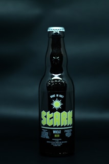 A dark beer bottle labeled 'Stark' with text indicating it is made in Bali and is a wheat beer. The bottle is set against a dark background, enhancing the visibility of the label.