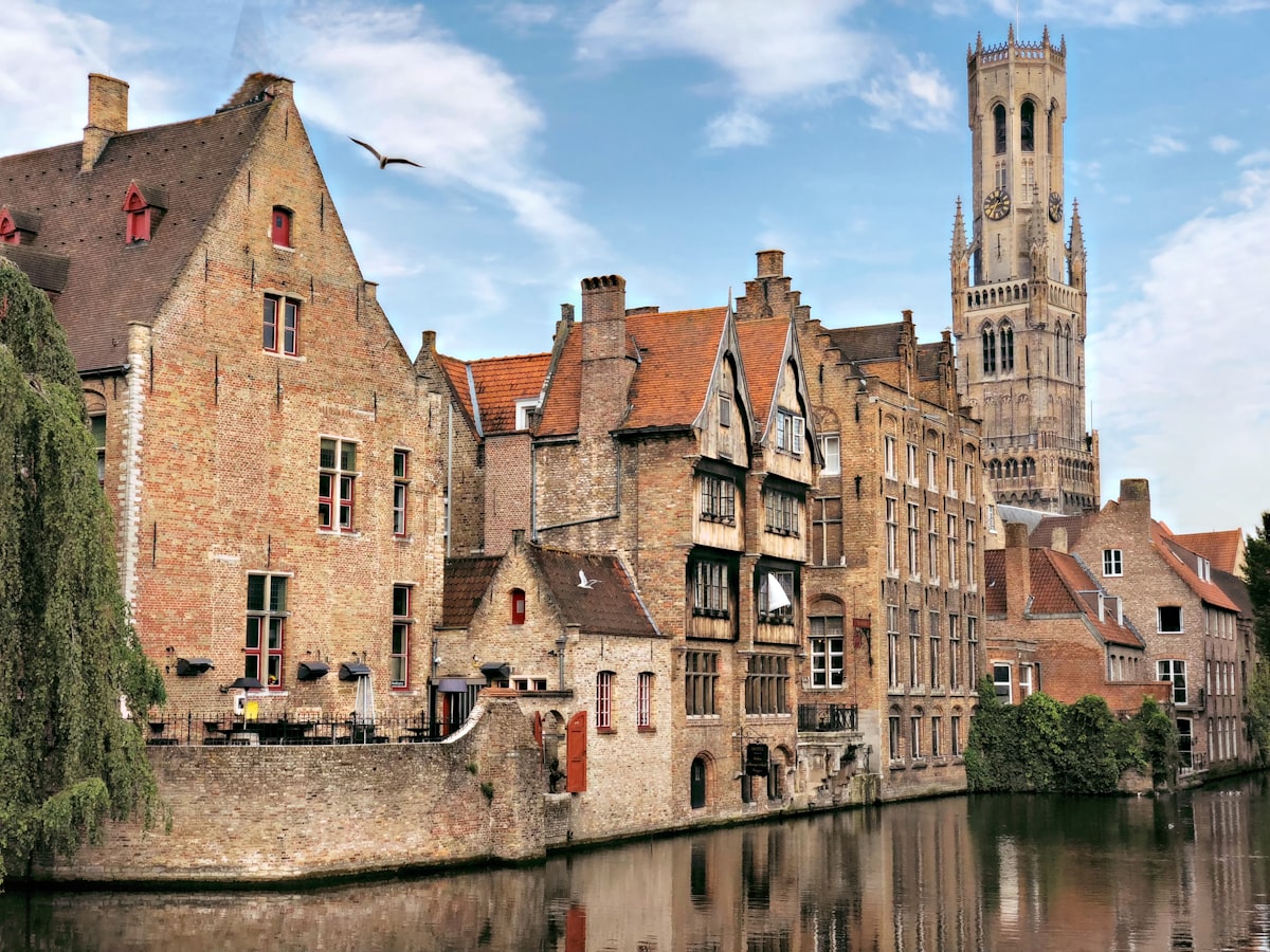 't Zand Bruges — Saturday market square with Concertgebouw in background