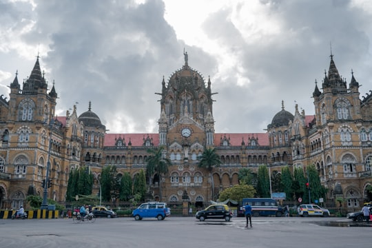 cars parked in front of brown concrete building during daytime in Chhatrapati Shivaji Statue India