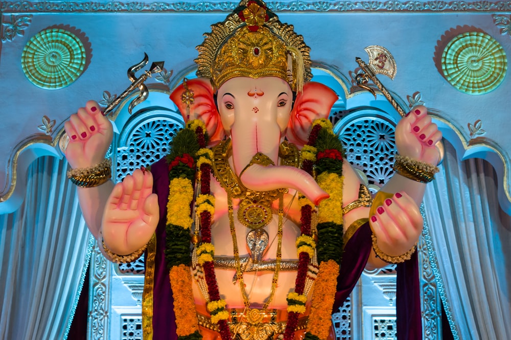 hindu deity figurine in front of blue and white wall