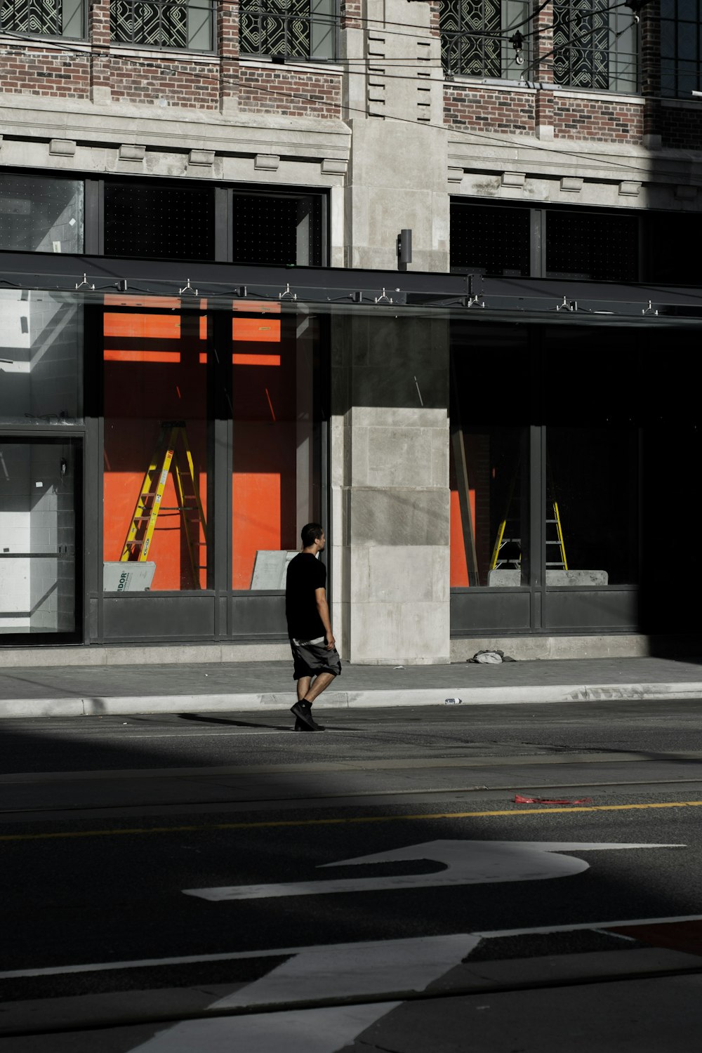 person in black jacket walking on sidewalk during daytime