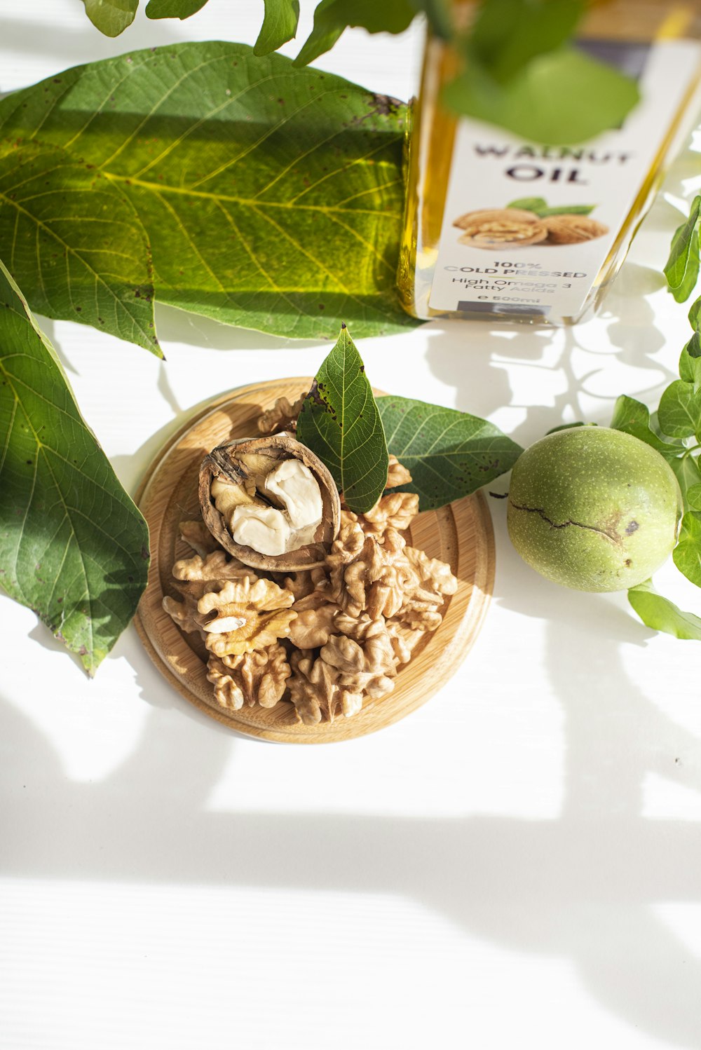 green round fruit beside brown nuts on white ceramic bowl