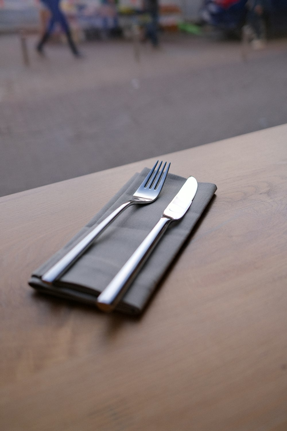 silver fork and bread knife on black leather tablet case