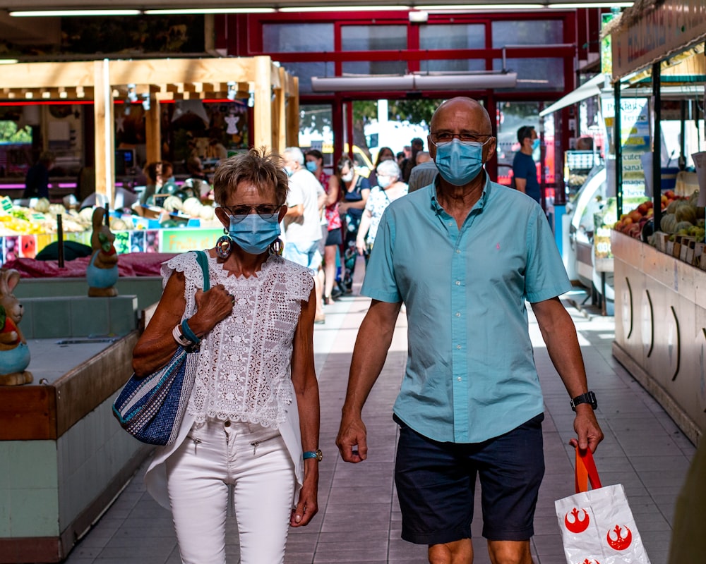 Mann im blauen Poloshirt neben Frau im blau-weißen Kleid