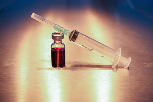 Close-up of a high-quality injectable medication vial with a deep plum-colored label.