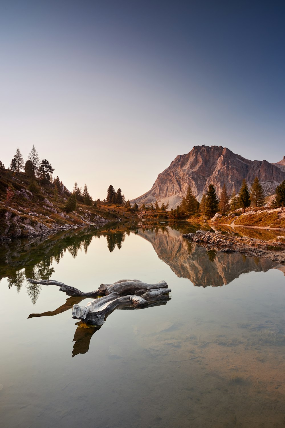 brown mountain near body of water during daytime