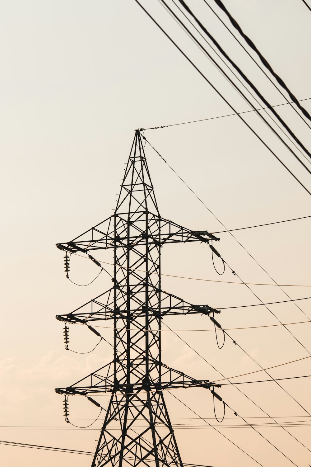 Poste eléctrico negro bajo el cielo blanco