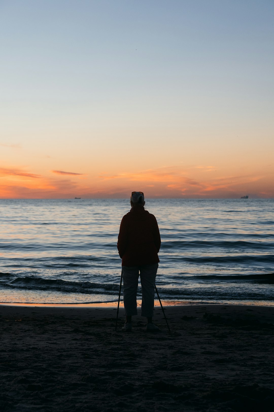 silhouette of man standing on beach during sunset