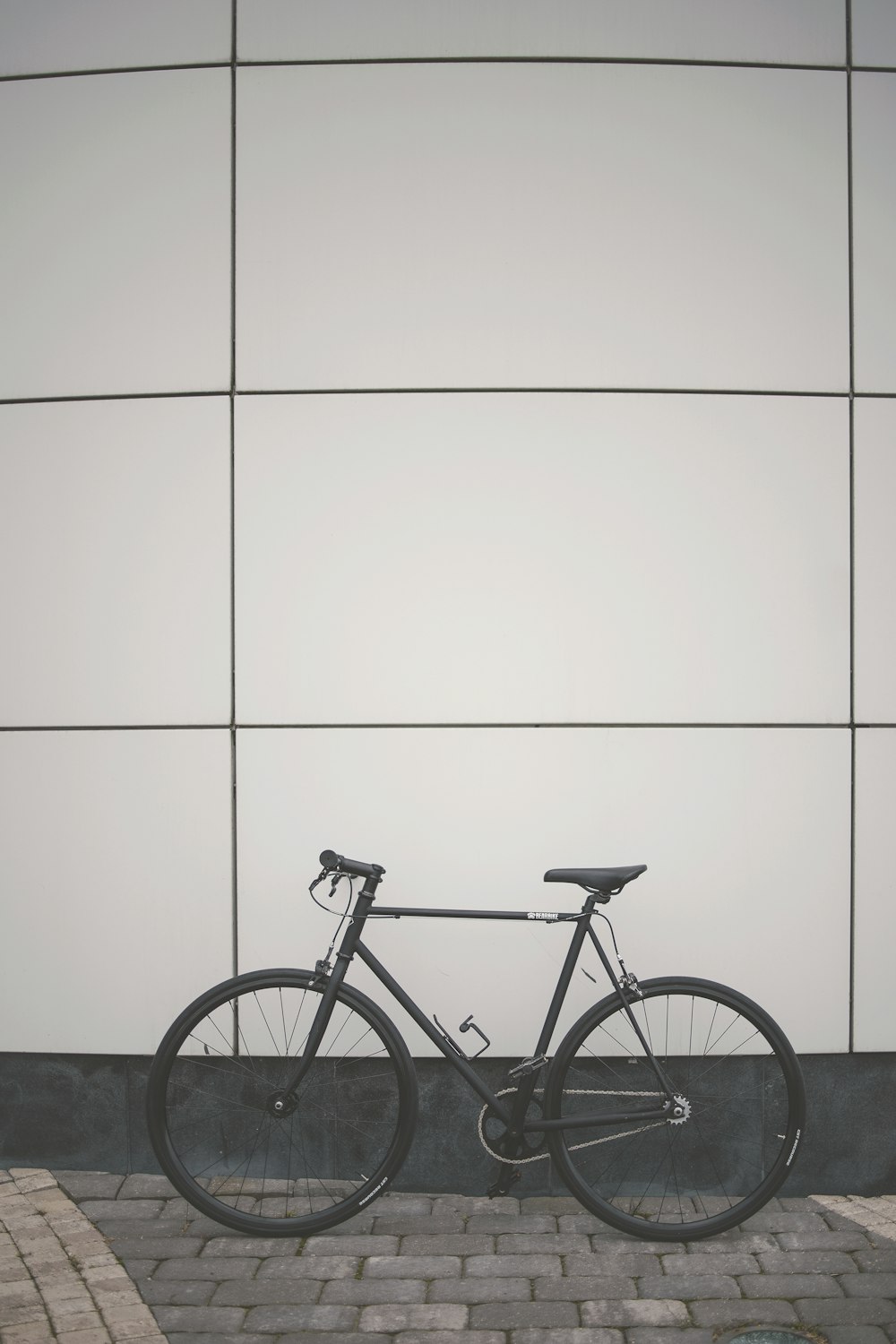 black city bike beside white wall