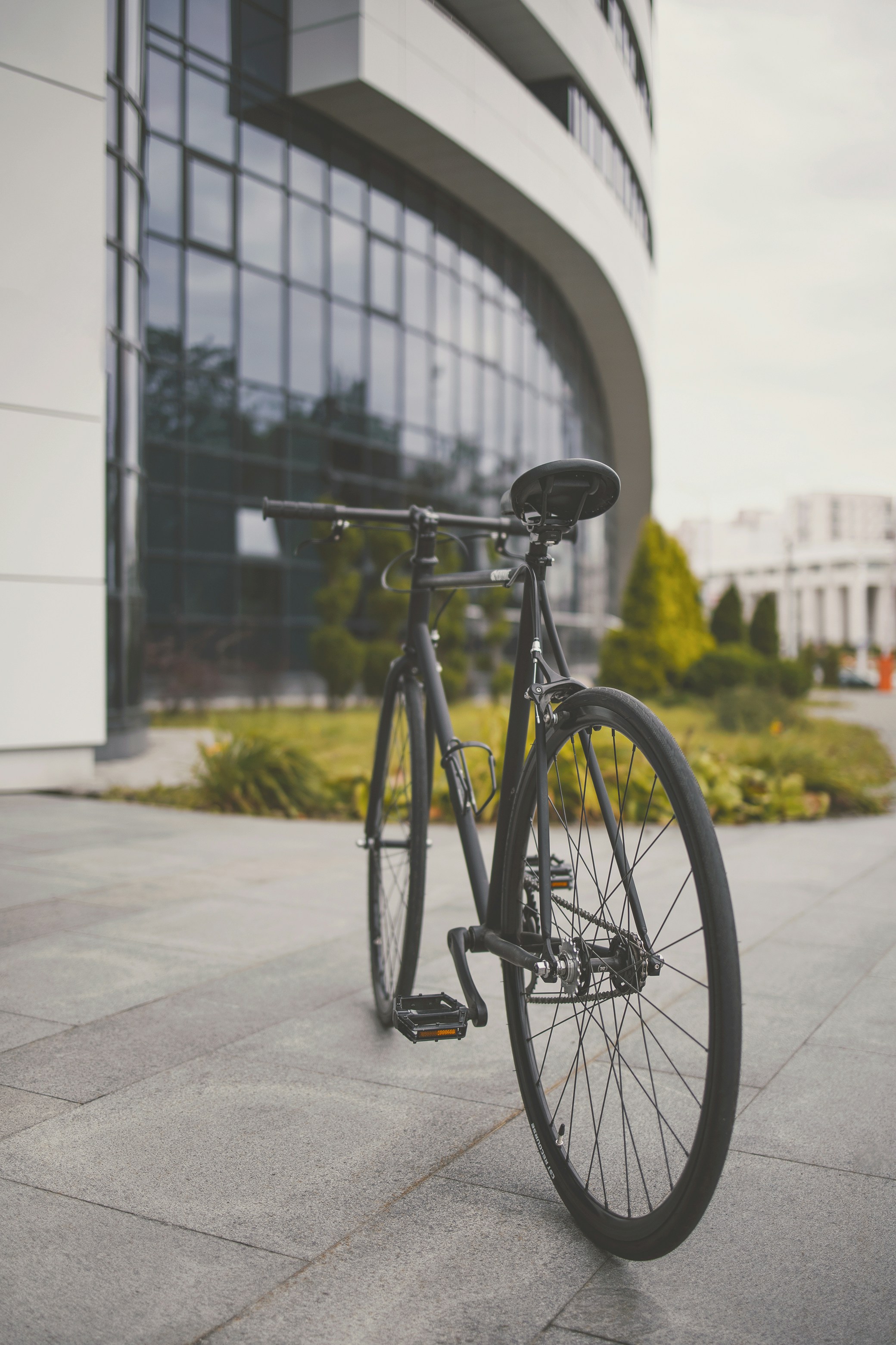 black city bike parked on sidewalk during daytime