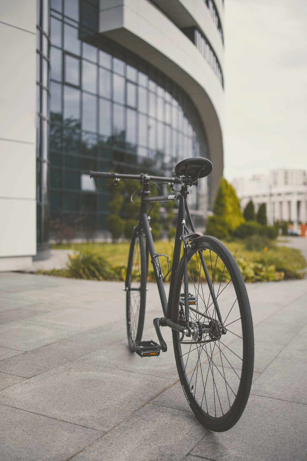 black city bike parked on sidewalk during daytime