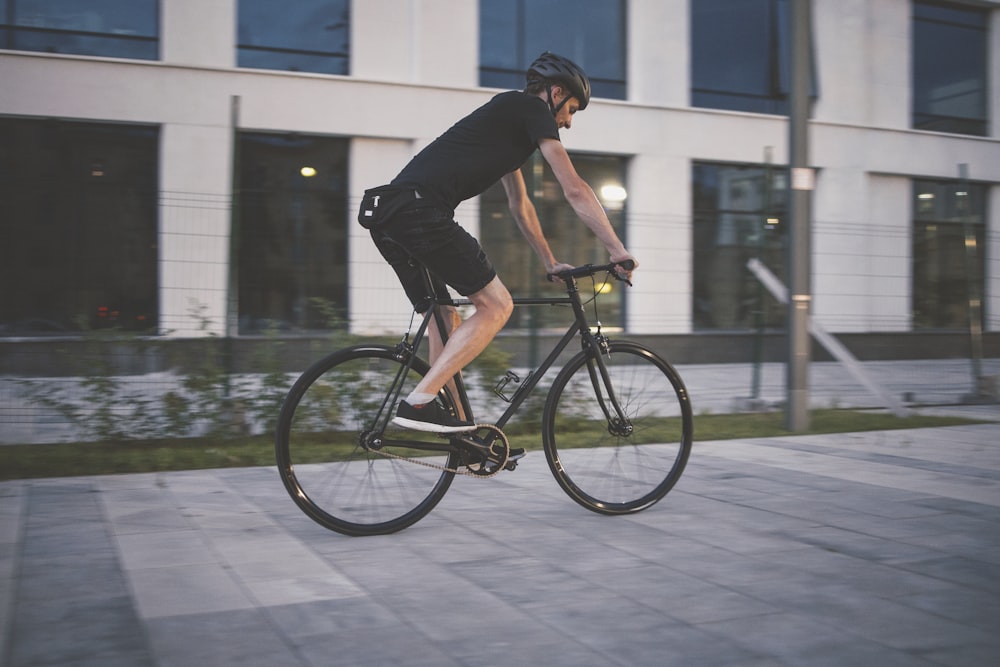 man in black t-shirt riding on black bicycle