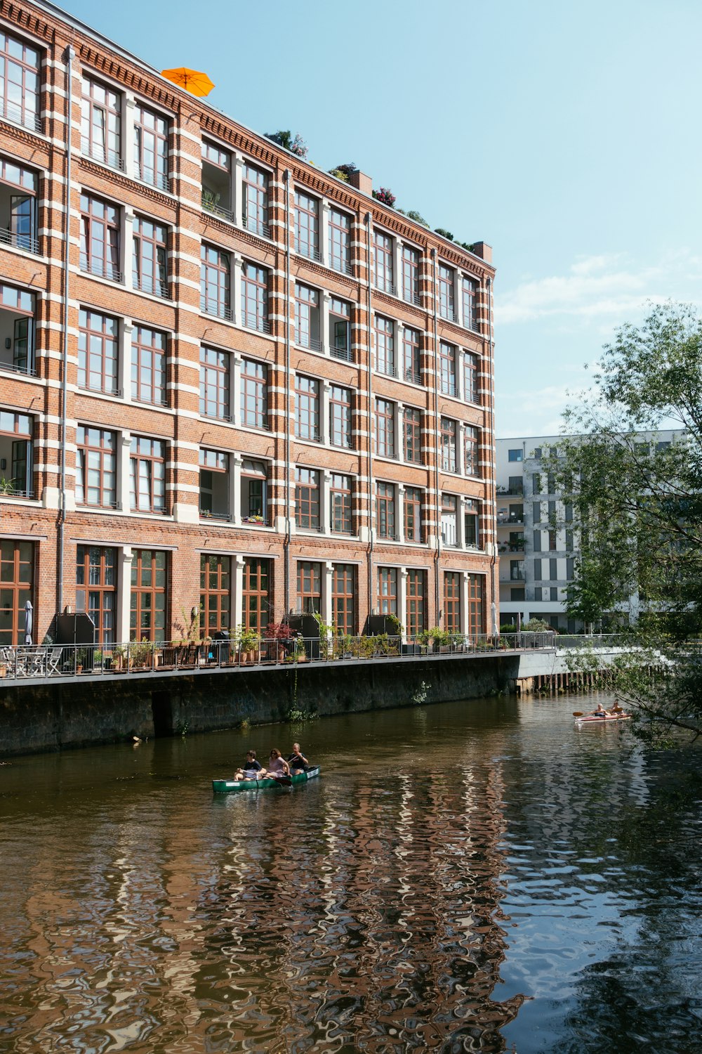 people riding on boat on river near brown concrete building during daytime