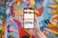 Hands holding a smartphone displaying a food ordering app with colorful menu items.