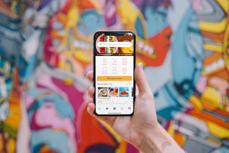 Hand holding a smartphone showing Enjyu’s menu on the GrabFood app interface.