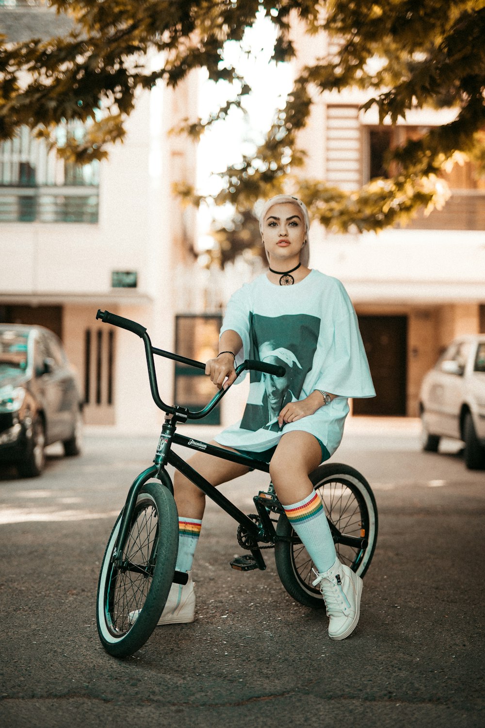 girl in green crew neck t-shirt riding on black and red bicycle during daytime