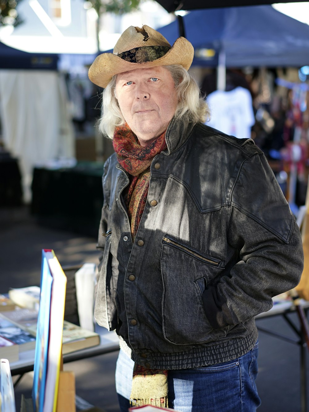 man in black leather jacket and brown cowboy hat