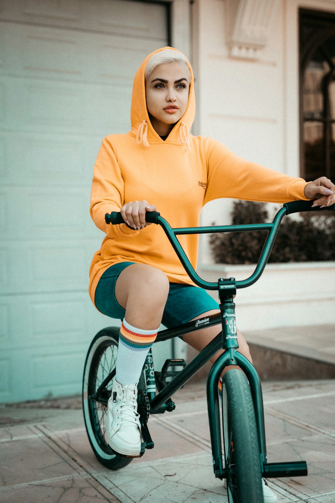 woman in yellow sweater riding on green bicycle