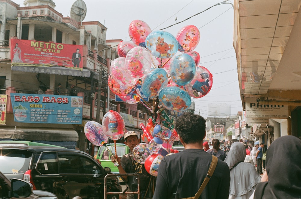 persone che camminano per strada con palloncini durante il giorno