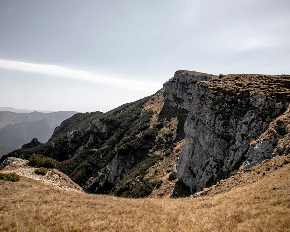 Brauner und grüner Berg tagsüber unter weißen Wolken