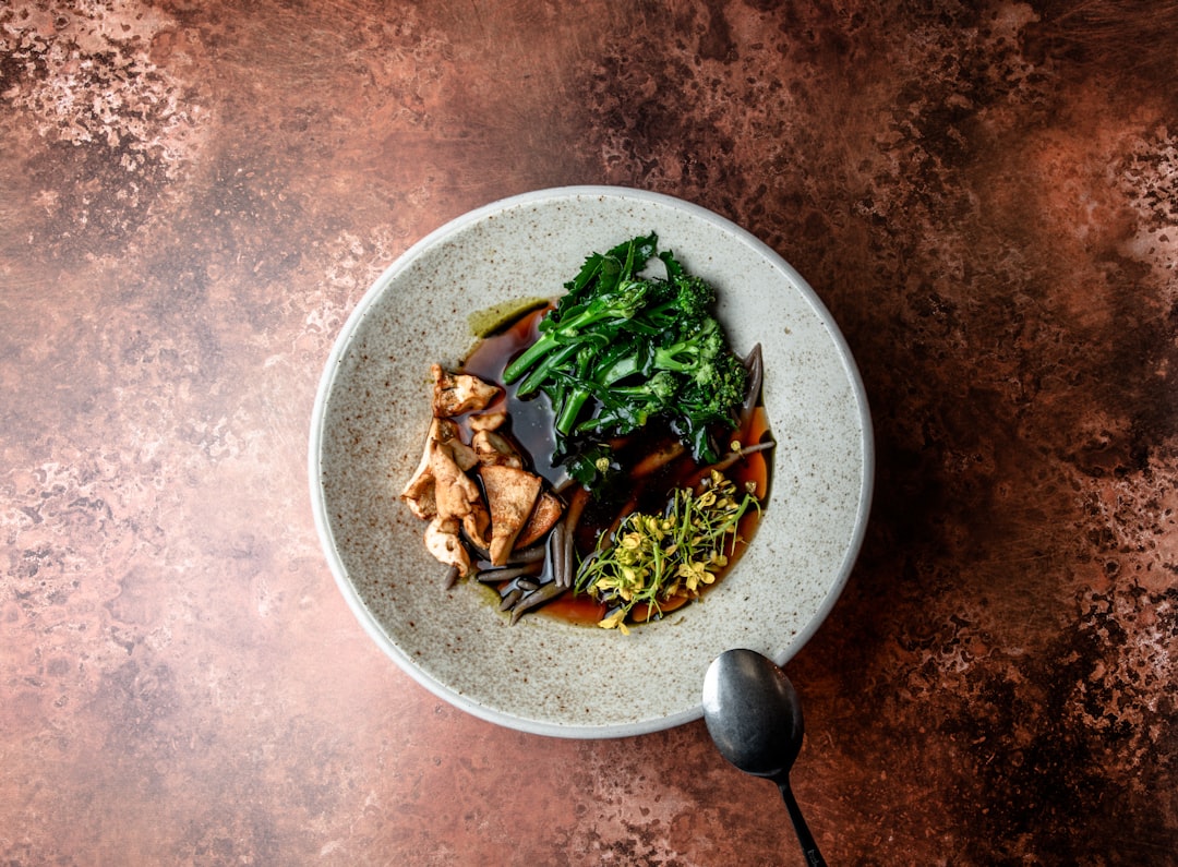 vegetable salad in white ceramic bowl, Vegan and gluten-free buckwheat noodles are bathed in a deep, dark, complex broth of roasted onions, meadowsweet vinegar and thyme.</p></figure><p>The garnishing can change although we are aiming to always have salt-baked Roscoff onions, a type of mushroom, and a wintery but tender green. 