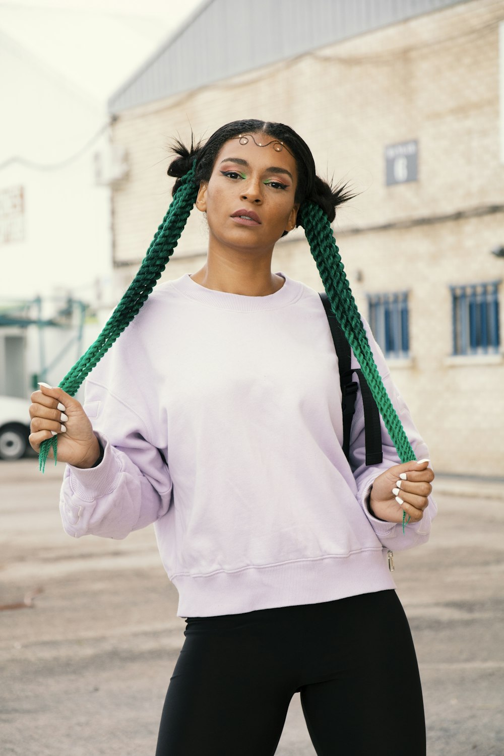 woman in white long sleeve shirt holding green rope