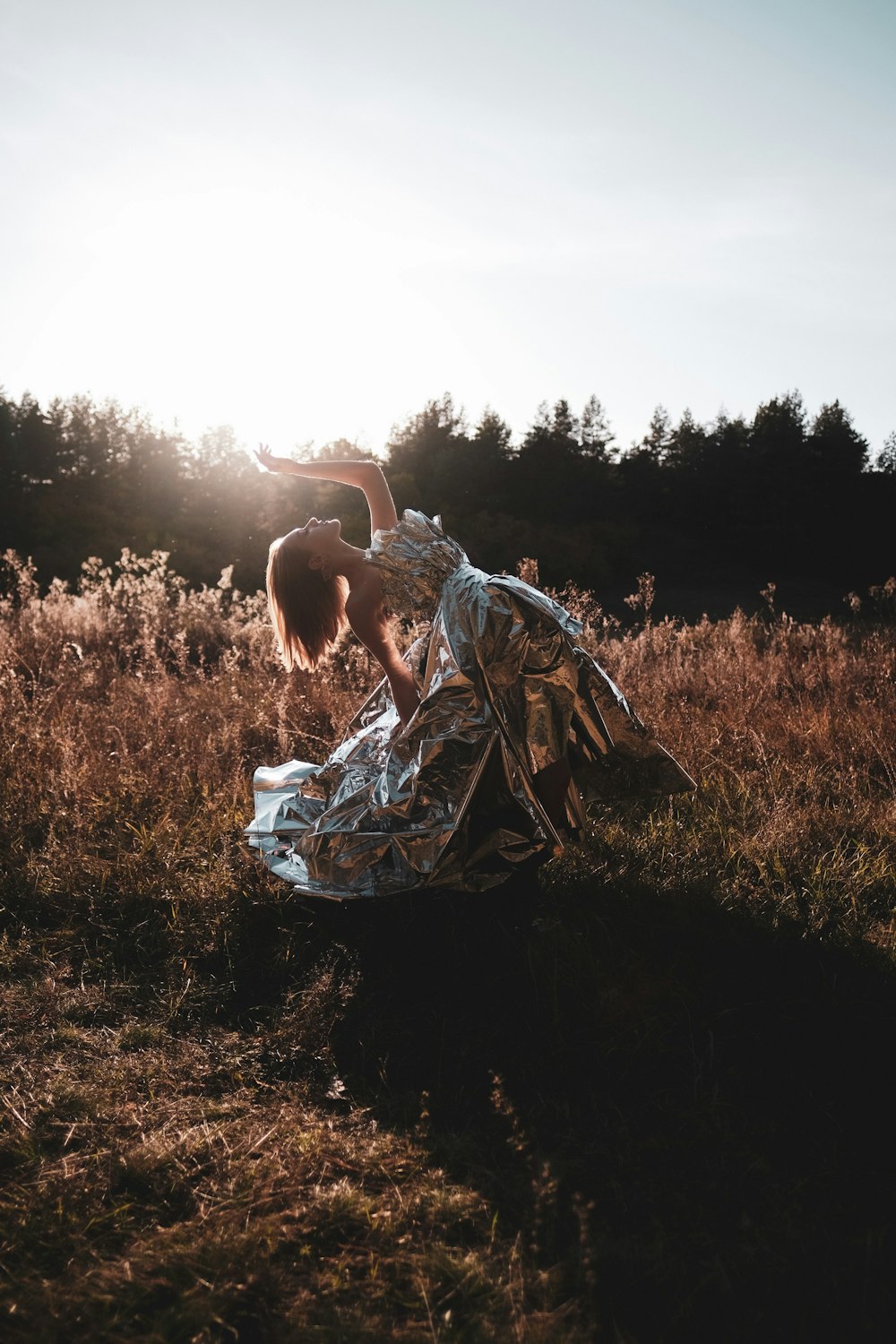 woman in white and black dress sitting on brown grass field during daytime