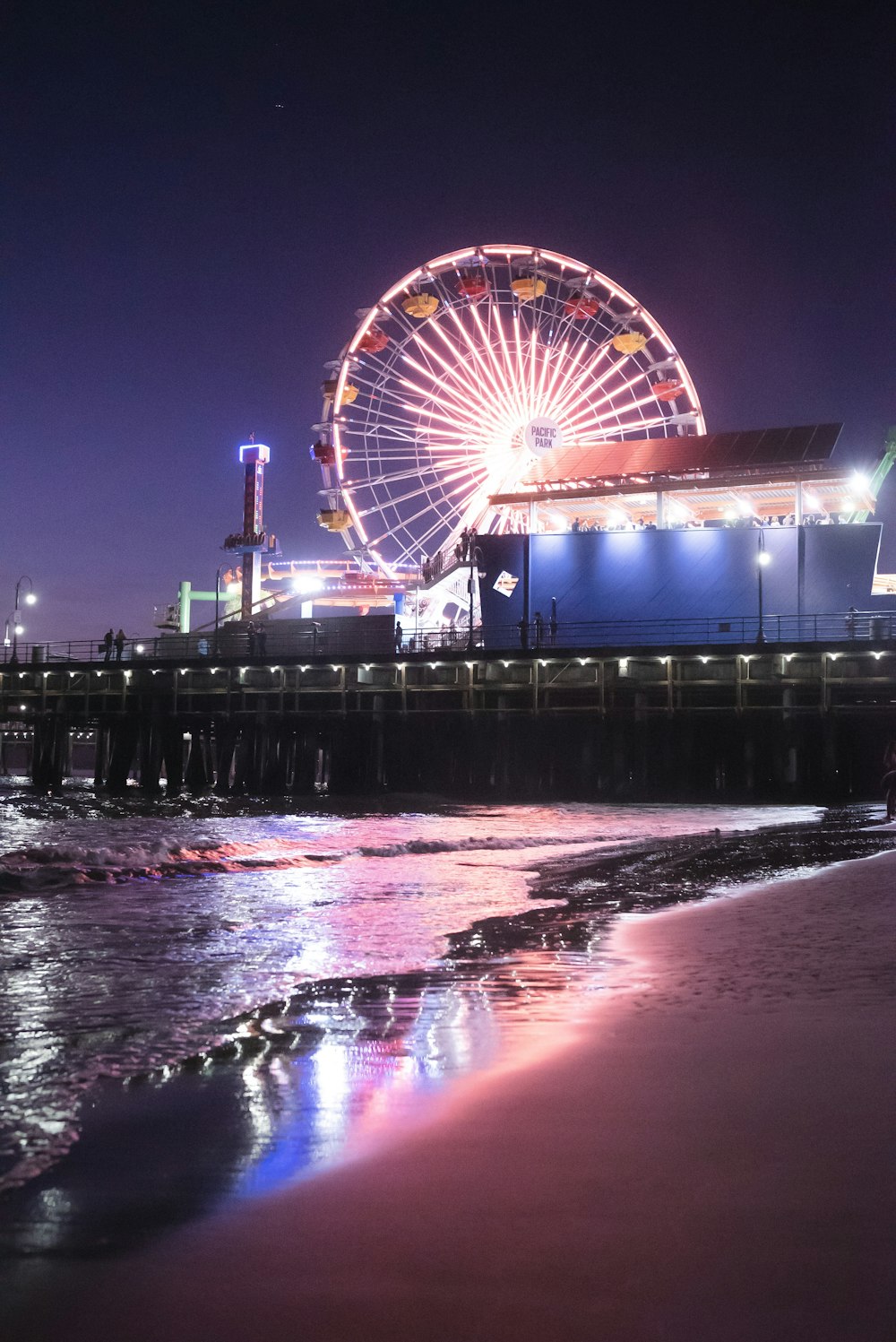 ferris wheel near body of water during night time