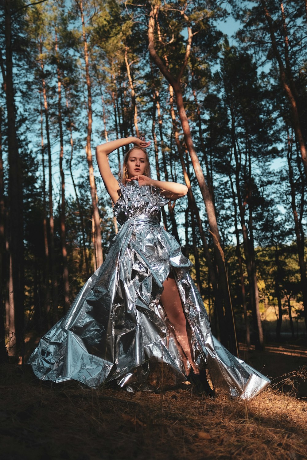 woman in gray dress standing on forest during daytime