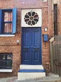 Close-up of a newly installed deep blue front door with sleek windows reflecting a sunny neighborhood.