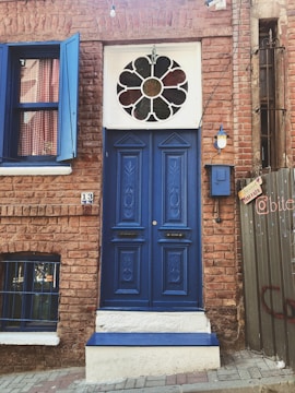 Close-up of a newly installed deep blue front door with sleek windows reflecting a sunny neighborhood.