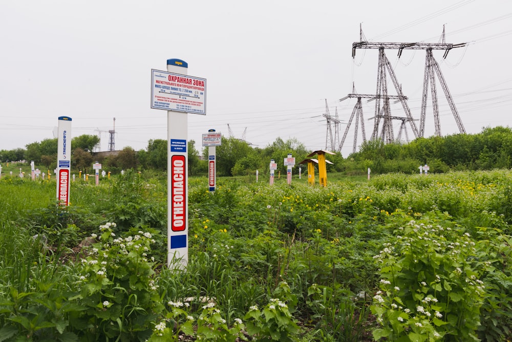 a sign in a field with power lines in the background