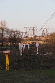 An industrial site with high voltage power lines in the background.