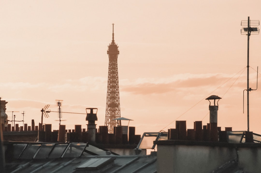 brown and white tower building, The Eiffel Tower from the Parisian rooftops at sunset