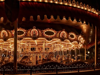 brown wooden carousel with lights turned on during night time