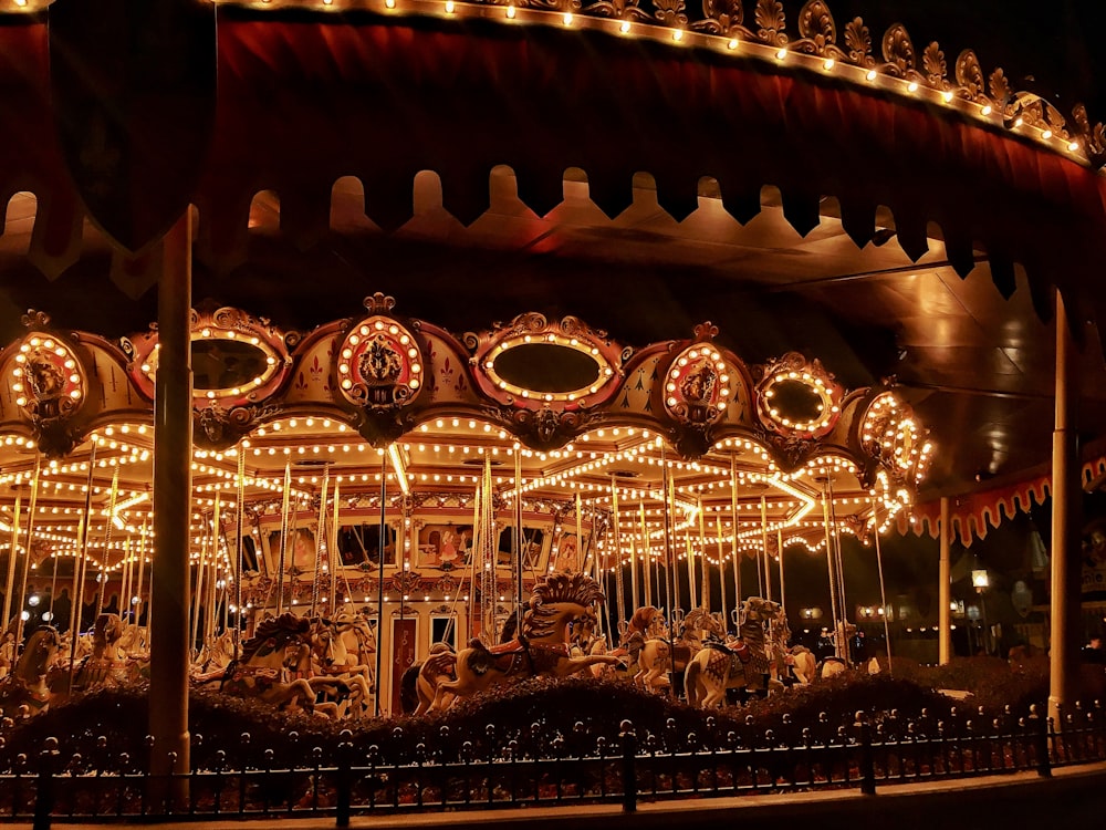 brown wooden carousel with lights turned on during night time