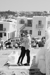 man in white dress shirt and black pants holding woman in white dress shirt