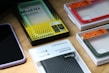 Variety of mobile screen protectors laid out on a wooden table showing different sizes and packaging.