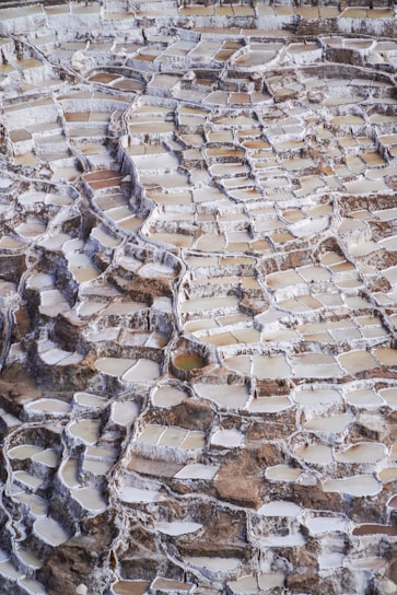 Panoramic view of the Maras Salt Mines in Peru, featuring multiple rectangular salt pools.