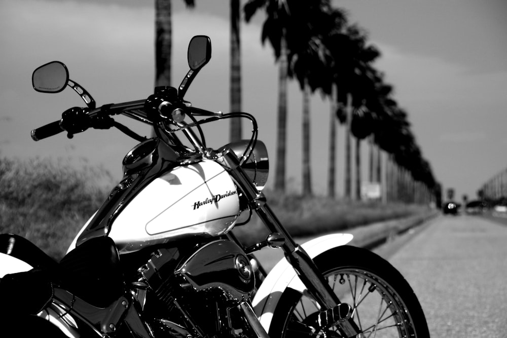 grayscale photo of motorcycle near tree