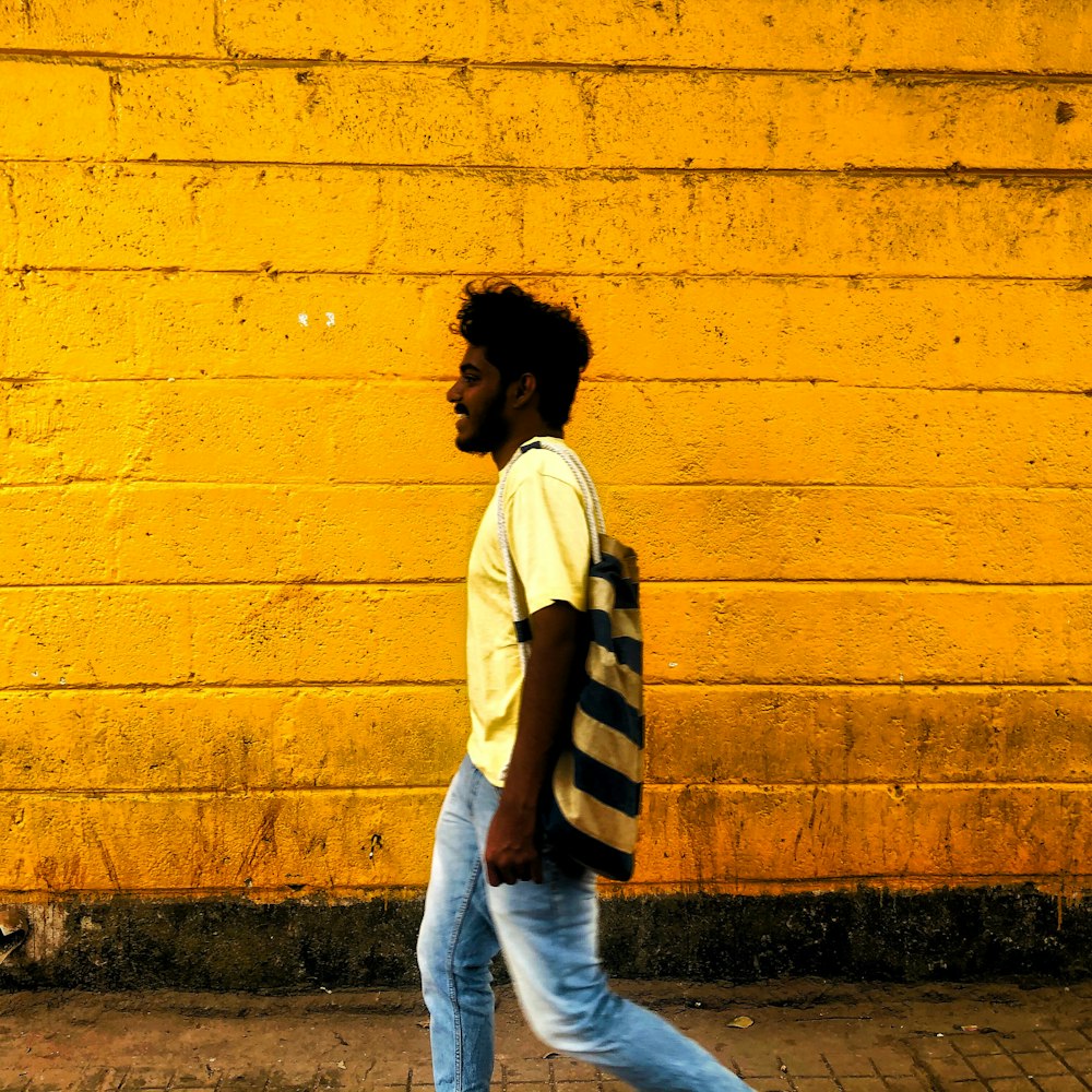 woman in white and black striped long sleeve shirt and blue denim jeans standing beside yellow