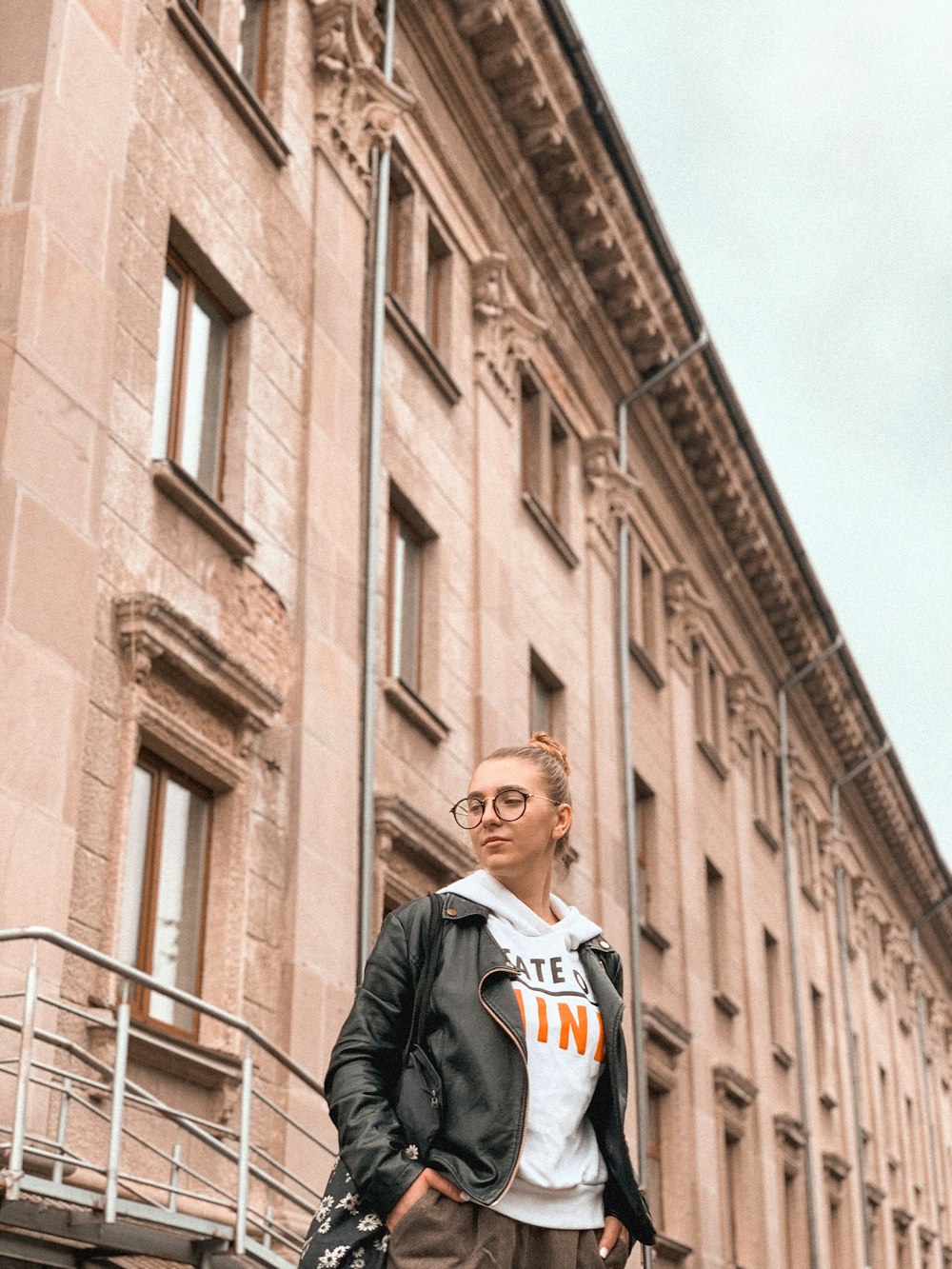 man in black jacket standing near brown concrete building during daytime