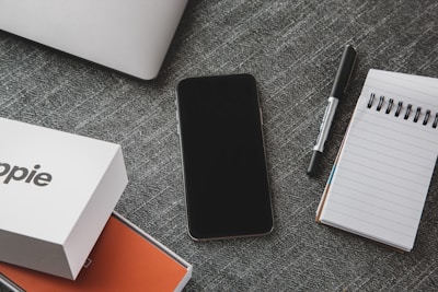 A creative flat lay of a notebook, pen, and a laptop showing affiliate sales data