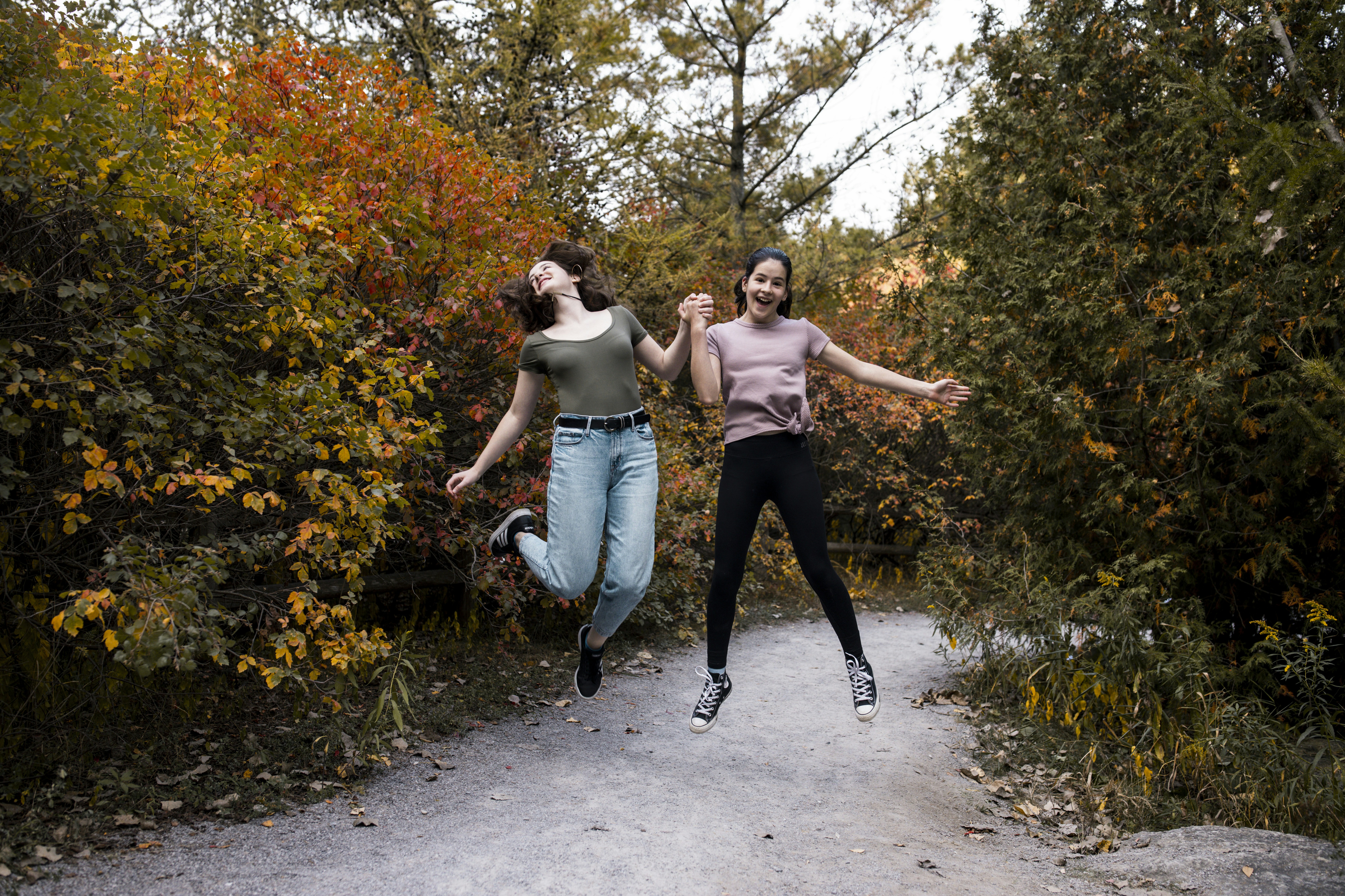 woman in white tank top and black leggings holding woman in white tank top