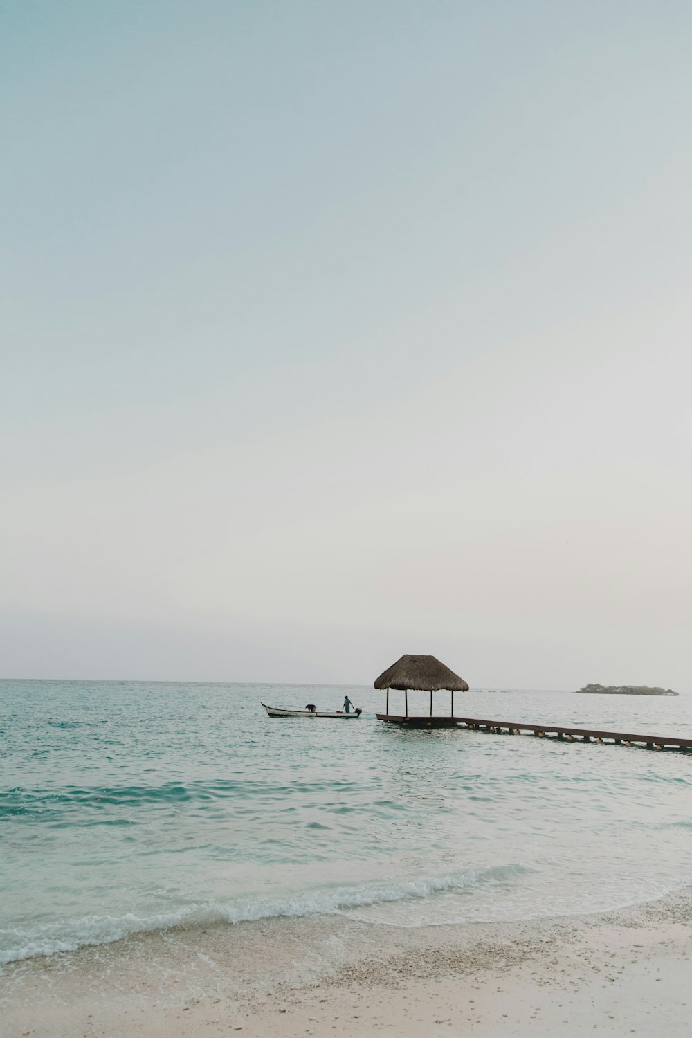 brown wooden dock on sea under white sky during daytime