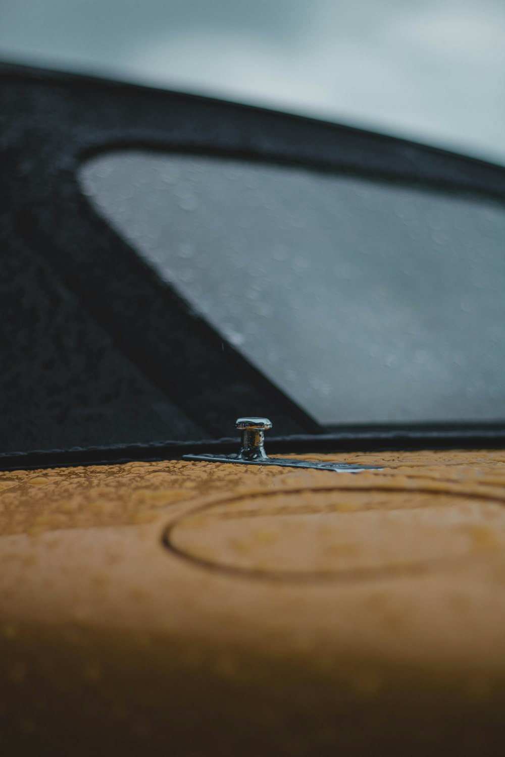 black car side mirror with water droplets