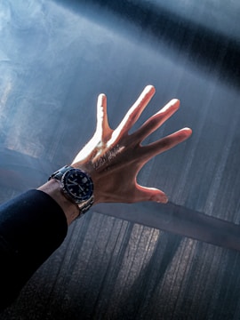 A shattered wrist bearing the mark, illuminated by stark gold and iron-grey lighting.